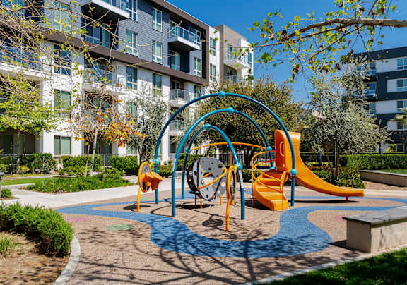 A playground with a slide, swings, and a roundabout.