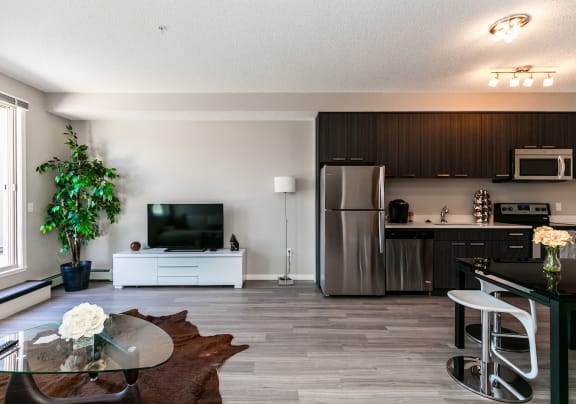 a kitchen and living room with a table and a tv