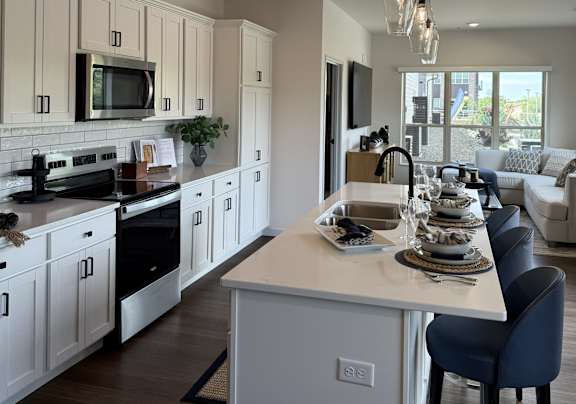 A modern kitchen with white cabinets and a central island.
