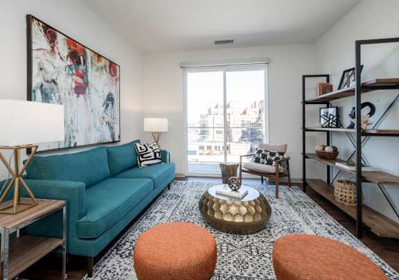 A living room with a blue couch, a coffee table, and a large painting on the wall.