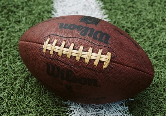 a football sitting on the grass on a field
