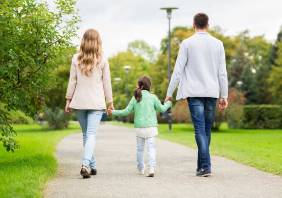 a family walking down a path in a park