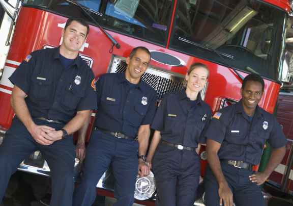 a group of firefighters posing in front of a fire truck