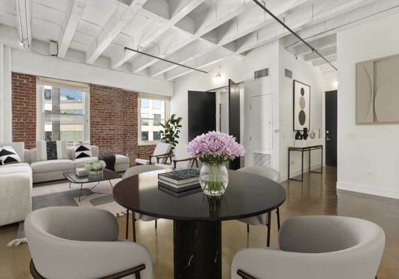 Living room with white furniture and a table with flowers at South Park Lofts, Los Angeles