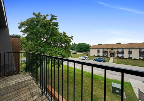 a balcony with a view of a yard and a building
