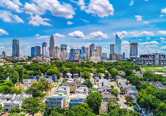 A cityscape with a mix of residential and commercial buildings under a clear sky.