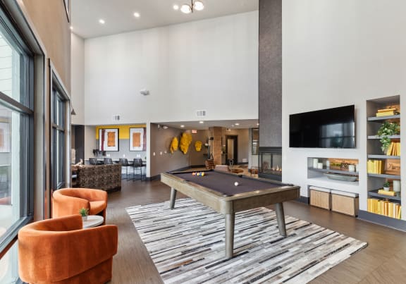 a spacious living room with a pool table and a tv