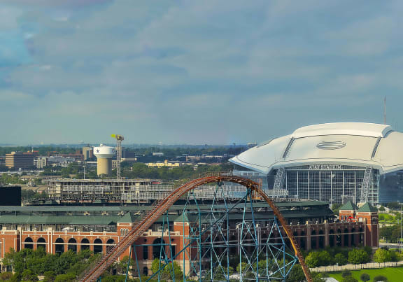 a view of a city with a roller coaster and a stadium