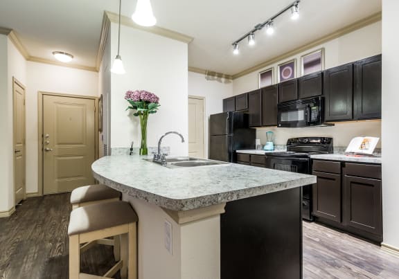 a kitchen with a large island with granite countertops