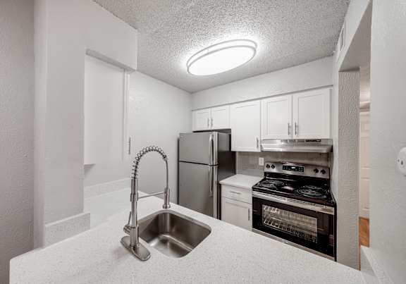 A kitchen with a stainless steel refrigerator, oven, and microwave.