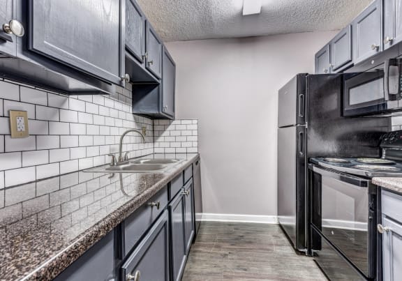 Whitney Manor Apartments in Gretna, LA photo of kitchen with subway tile back splash and hardwood floors