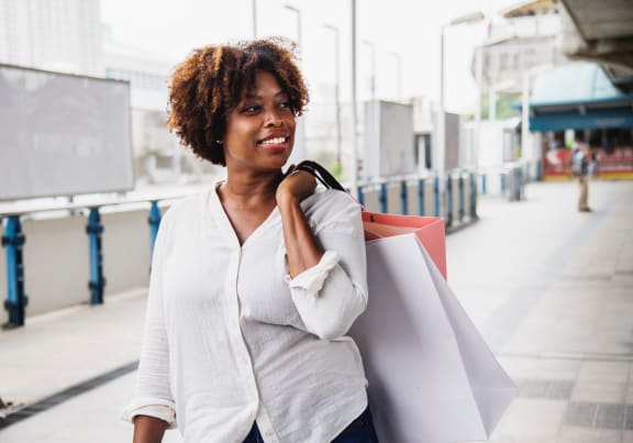 a woman walking down a street holding shopping bags