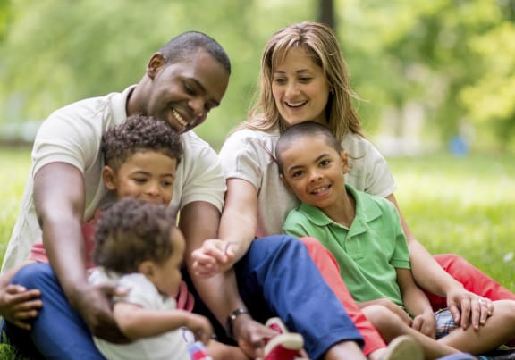 a family sitting on the grass with their children