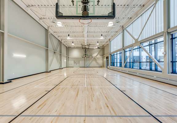 A large, empty gymnasium with wooden floors and a high ceiling.