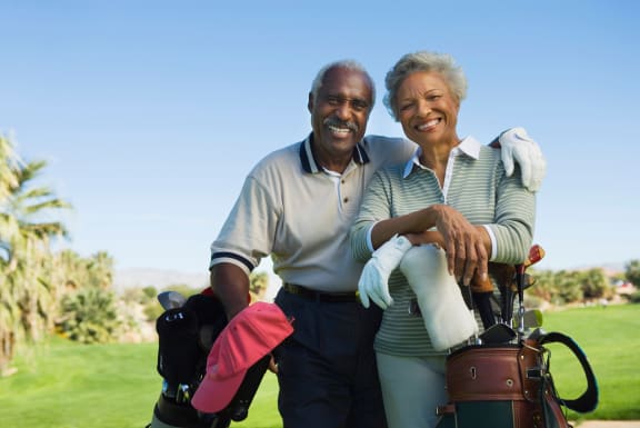 a man and a woman standing on a golf course with a golf bag at Mira at Palmer Ranch, Sarasota, FL 34238
