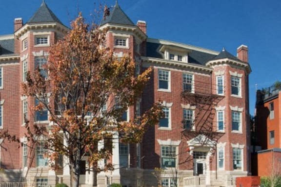 a large brick building with a tree in front of it