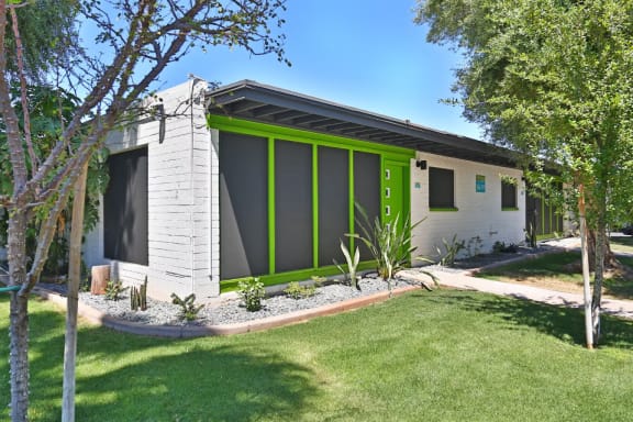 a white and green house with trees in front of it
