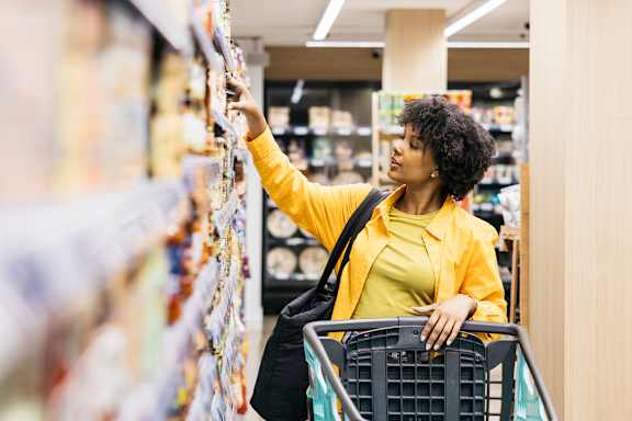 A woman in a yellow jacket is shopping in a store.