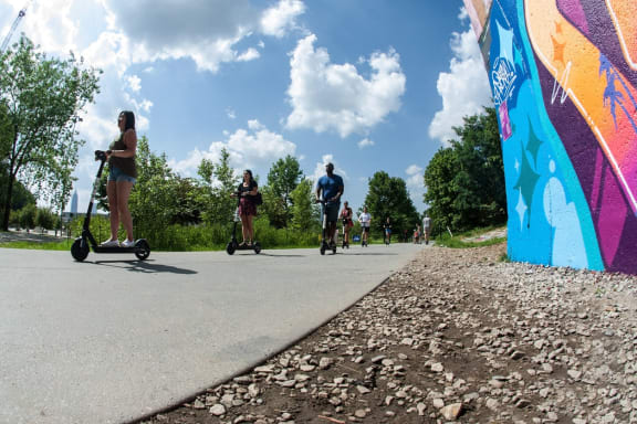 people riding scooters on a path in a park at Glenwood at Grant Park Apartments, Georgia, 30316