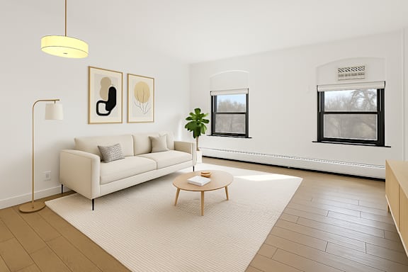 A spacious room with wooden flooring and large windows.