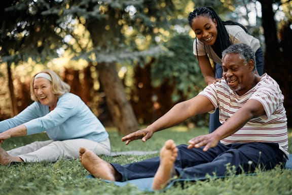 a group of people sitting on the grass in a park