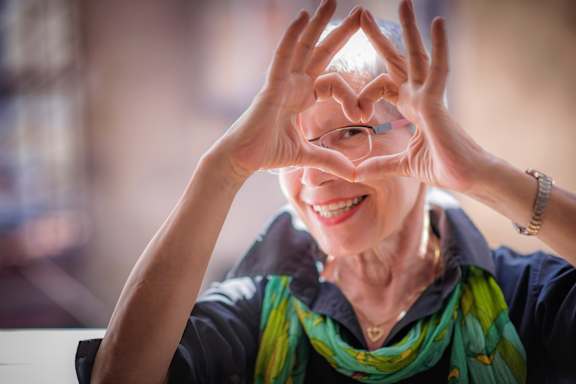 Smiling elderly woman making a heart shape with her hands at Humboldt Senior 55+ Apartments, Saint Paul, MN, 55107