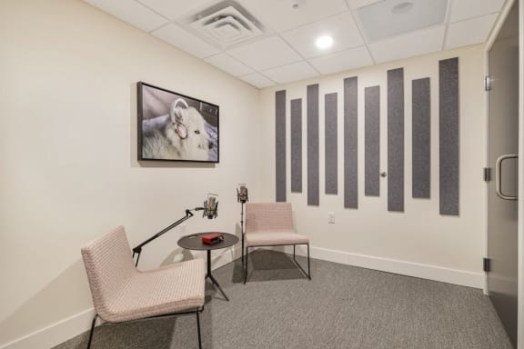 a conference room with two chairs and a table and a picture of a goat on