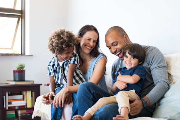 a couple sitting on a couch with their dog