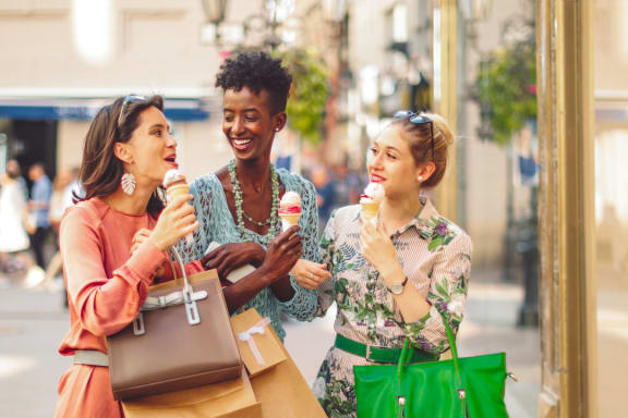 three women walking down the street with shopping bags and ice cream at Palm Crossing, Florida, 34787