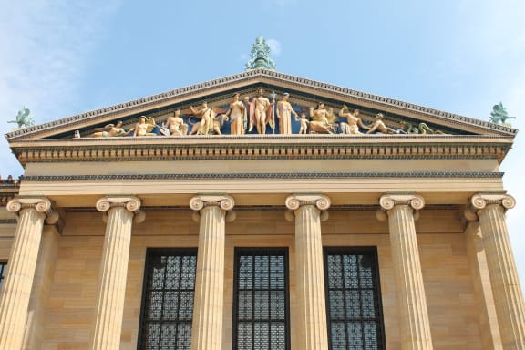 A building with a statue on top and columns on the bottom.