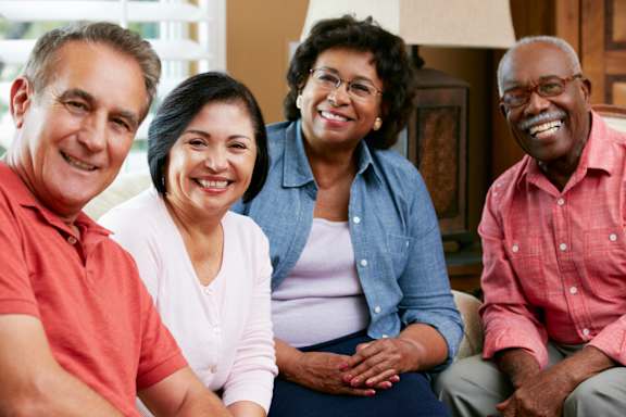 Four people sitting together and smiling.