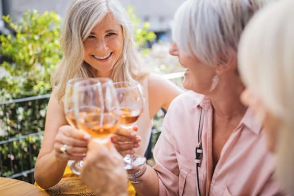 Two women holding wine glasses and smiling.