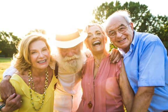 Four people posing for a photo in a field.