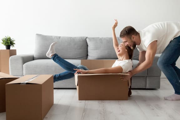 a man and a woman playing with boxes in a living room at Altis Santa Barbara, Naples, 34104