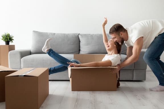 a man and a woman playing with boxes in a living room at Altis Blue Lake, Lake Worth, 33467