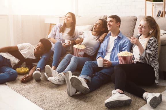 a group of people sitting on a couch eating popcorn and watching tv at Altis Blue Lake, Lake Worth, 33467