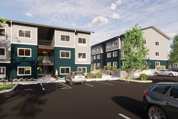 A modern apartment complex with a parking lot in front.