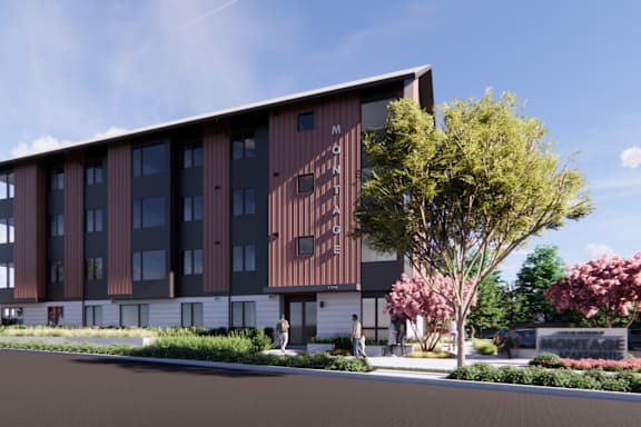 A modern building with a brown facade and a tree in front.