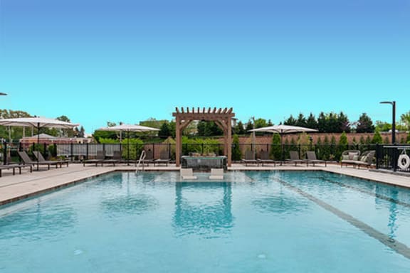 a large swimming pool with chairs and umbrellas