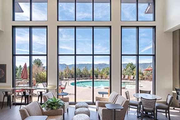 A large room with a pool table and a view of the mountains.