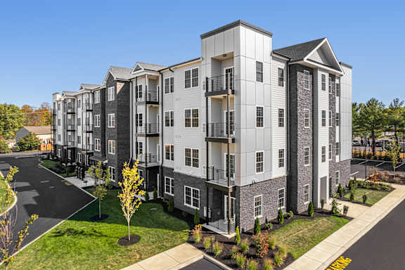 Apartment complex with a mix of grey and white buildings.