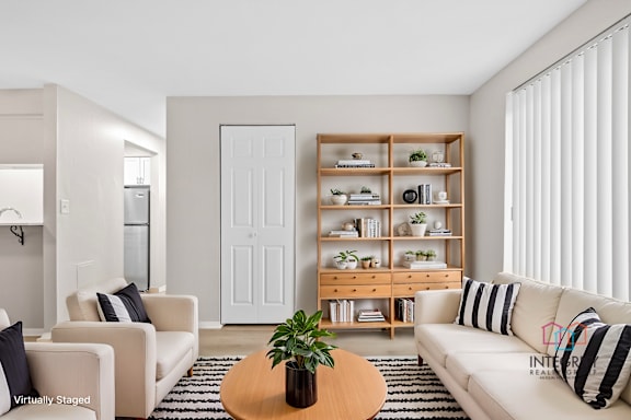 A living room with a white couch, a wooden coffee table, and a white door.