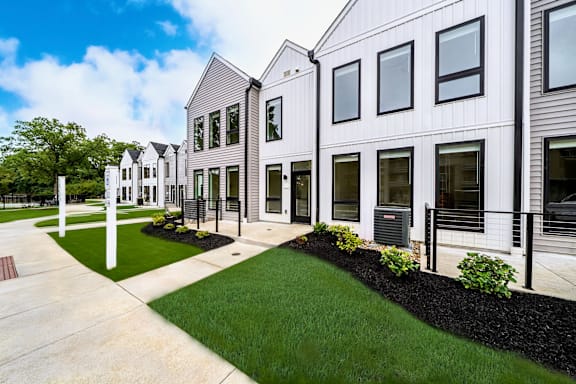A row of modern houses with white fences and green lawns at Westwood Meadows, Westlake, OH, 44145