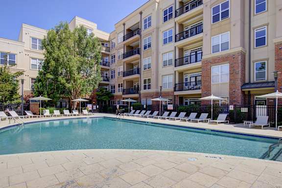 A large swimming pool in front of apartment buildings.