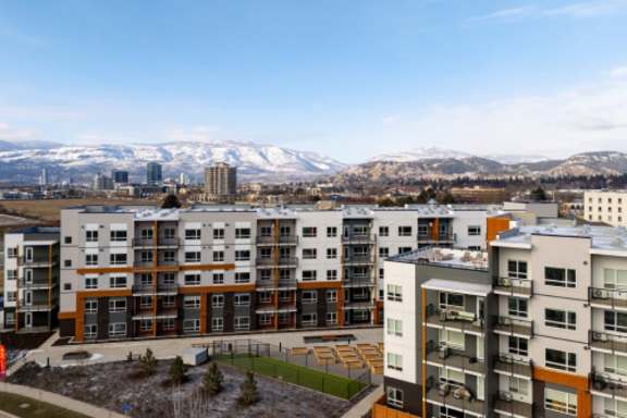 Apartment buildings with a snowy mountain range in the background.