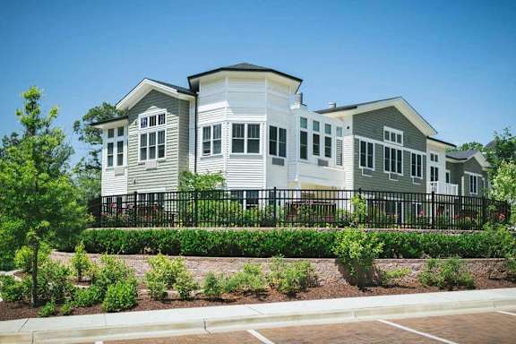 a row of white houses with a garden in front of them