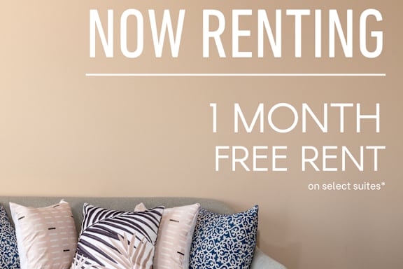 A living room with a couch and pillows, advertising a free rent offer.