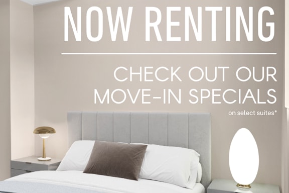 A bedroom with a bed, nightstand, and lamp advertising Parkway Apartments.