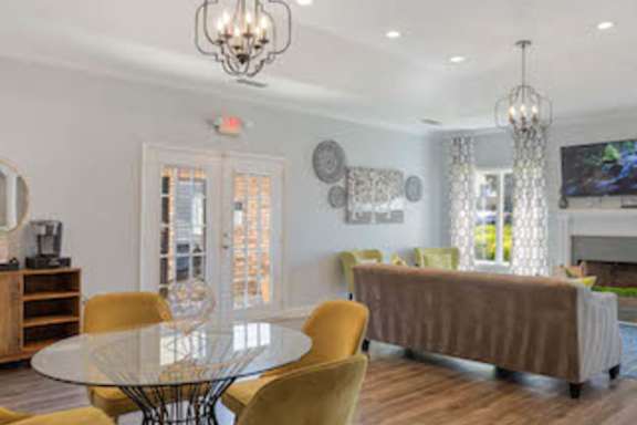 A dining room with a glass table and yellow chairs.