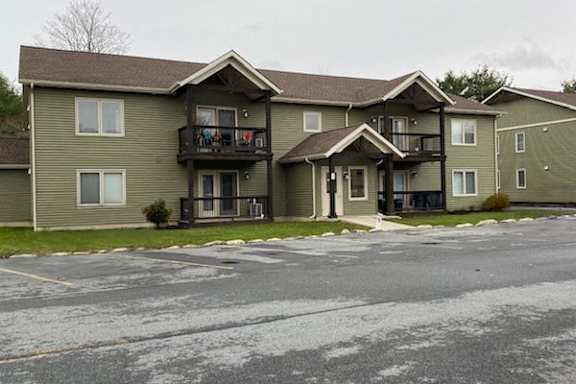 A large two-story apartment building with a balcony on the second floor.